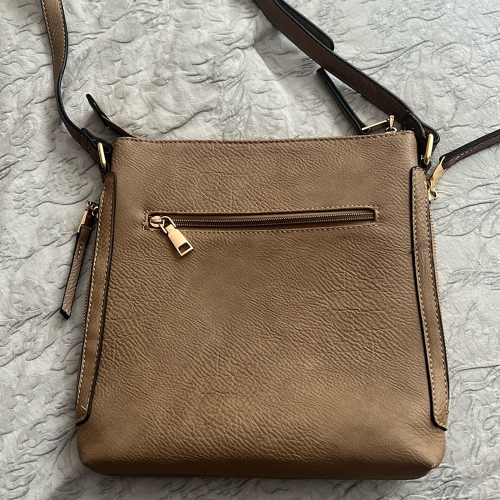 Crossbody bag for women. Pre-owned. Lots of zippers. Good condition.
